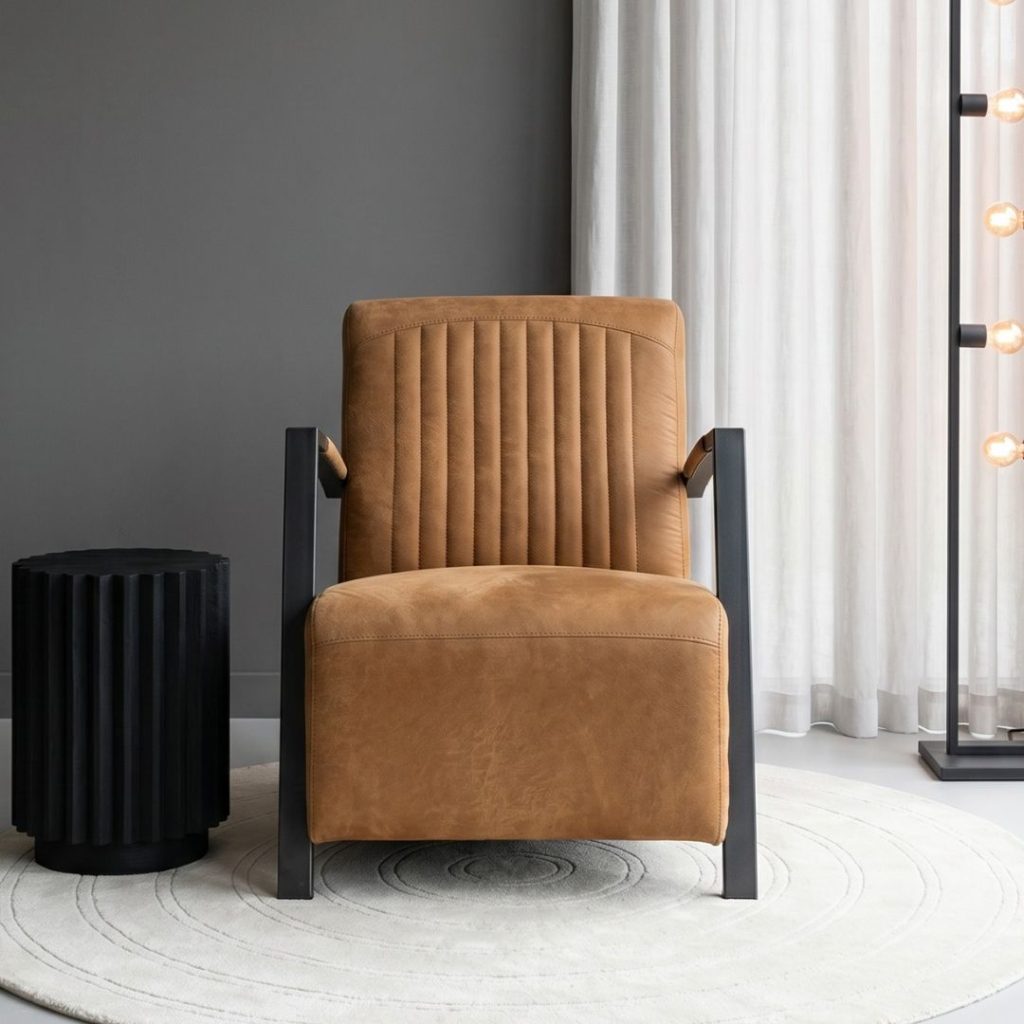 Industriële fauteuil Sixty van HUUS bekleed in een cognac kleurige missouri stof.
