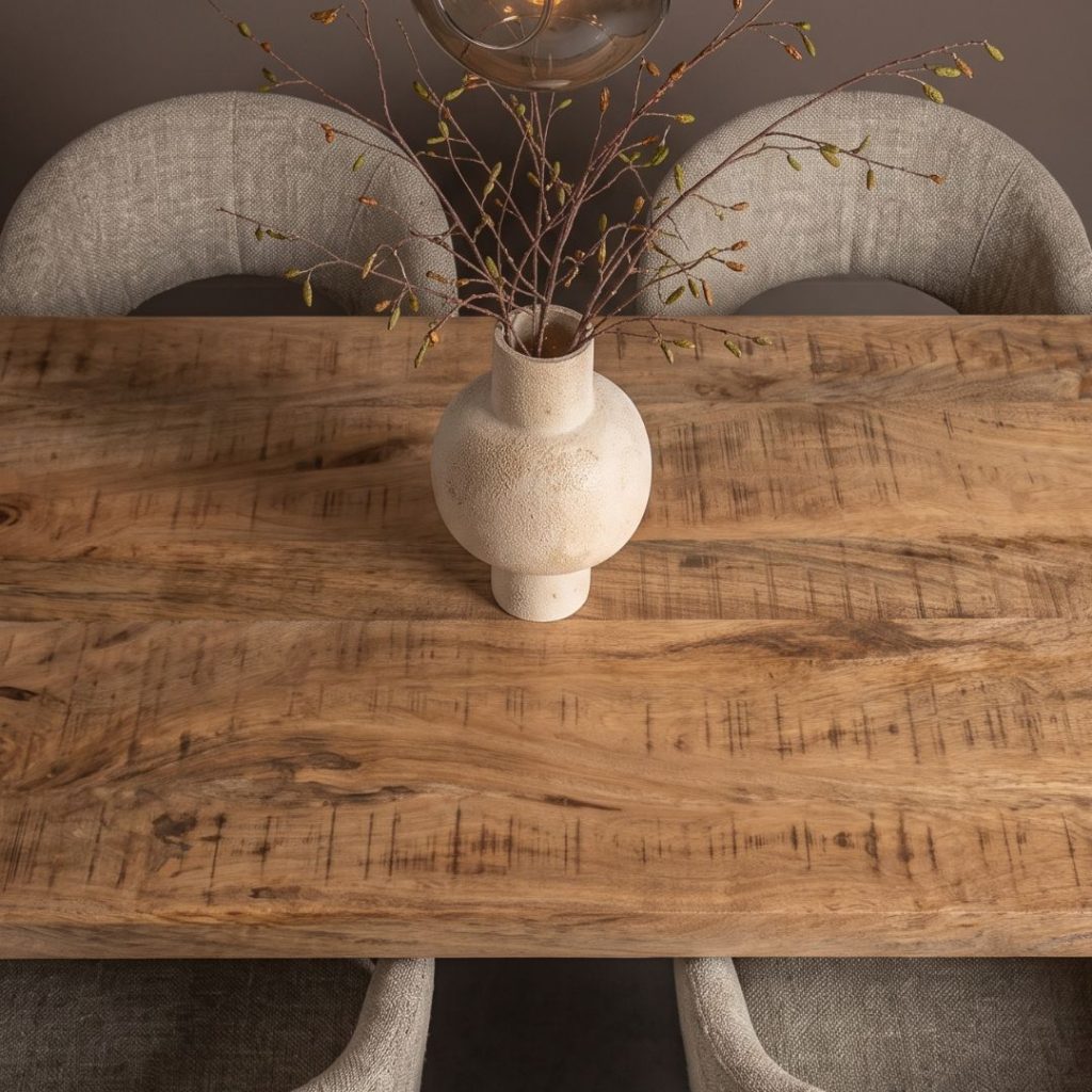 Detail foto van eettafel Dominique van HUUS, gemaakt van massief onbewerkt mangohout en zwart metaal.