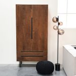 Kast Rio hoog van LABEL51 in espresso mangohout met twee deuren en zwart metalen poten tegen een lichte wand