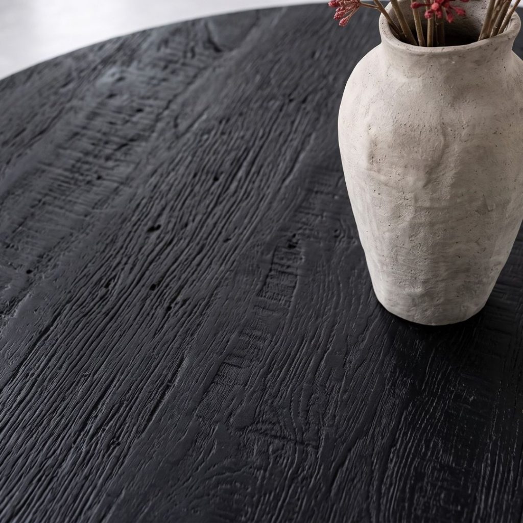 Detailfoto van het gezandstraalde mangohouten tafelblad van eettafel madrid rond in de kleur zwart