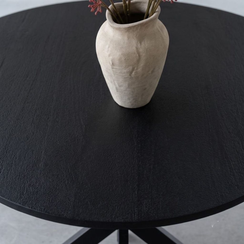 Detailfoto van het gezandstraalde mangohouten tafelblad van eettafel madrid rond in de kleur zwart
