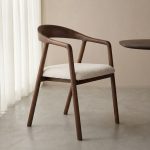 Eetkamerstoel Lone van LABEL51 met een naturel kleurige zitting en een walnoot eikenhout frame.