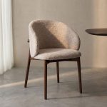 Eetkamerstoel Nagano van LABEL51 met een walnoot essenhout frame en een beige geweven zitting.
